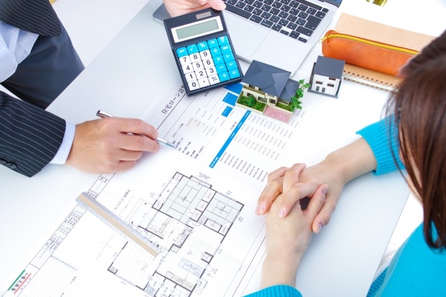 建築図面を見ながら商談する二人