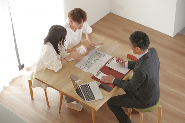 テーブルで住宅プランを検討する人々
