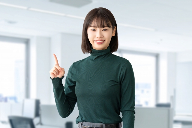 オフィスで指を立てる女性