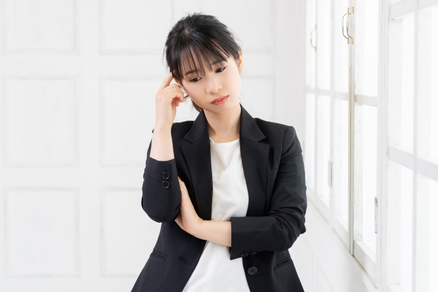 窓際で考え込む若いビジネスウーマン
